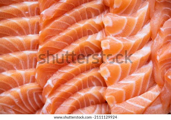 close up salmon fillet slices texture. Row salmon fish sliced on plate at Japanese restaurant.