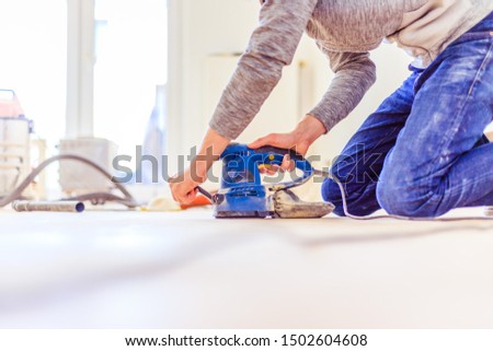 Close up of a sander power tool for DIY on wooden parquet floor