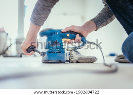 Close up of a sander power tool for DIY on wooden parquet floor