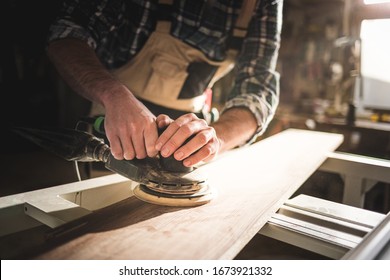 Close up of sanding a wood with orbital sander at workshop - Powered by Shutterstock