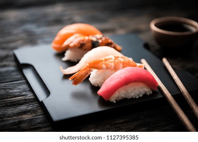 close up of sashimi sushi set with chopsticks and soy on black background - Powered by Shutterstock