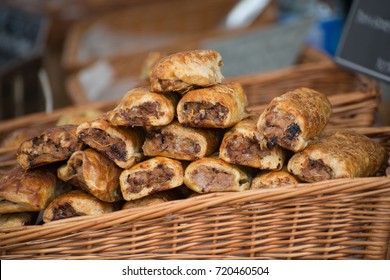 Close Up Of Sausage Rolls In Golden Pastry With Wicker Basket At An Outdoor Food Festival In The UK