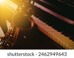 close up of saxophone and piano keys with window light, copy space, music background