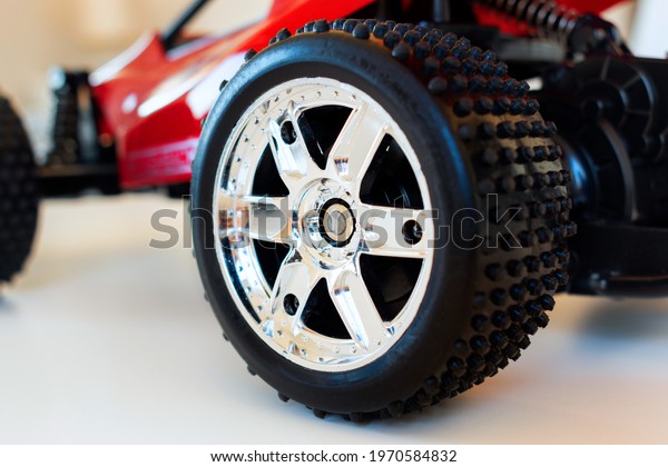 Close up of a scale model wheel\
of a sportive car. Rim and tire of a model racing sports\
car.