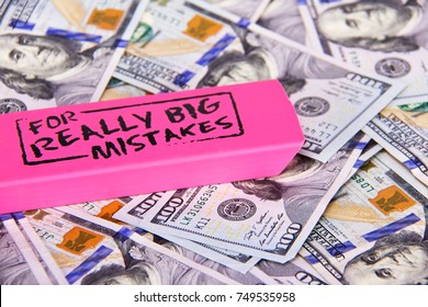 Close Up Scattered US Dollars With Message On Pink Eraser For Really Big Mistake.  Concept Fixing Financial, Business, Taxes, Savings, Loan Mistakes