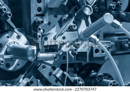 Close up scene the coil spring machine in light blue. The mechanical parts manufacturing concept.