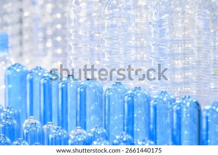 Close up scene of group of preform shape of PET bottle products and PET bottle background. The raw material for plastic bottle manufacturing process.