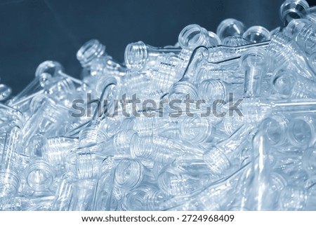 Close up scene of group of preform shape of PET bottle products in the light blue scene.  The raw material for plastic bottle manufacturing process.