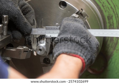 Close up scene the lath machine operator measuring dimension of turning parts by Vernier caliper. The quality control on turning machine. 