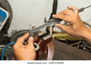 Close up scene the machine operator measuring dimension of cast iron parts by Vernier caliper. The quality control on turning machine.  - Powered by Shutterstock