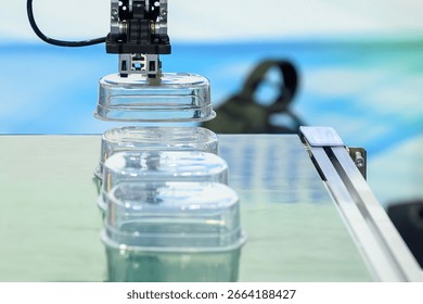 Close up scene material handling process the food container by robotic system from injection machine.  The food container production process by automatic system from plastic injection mold machine.