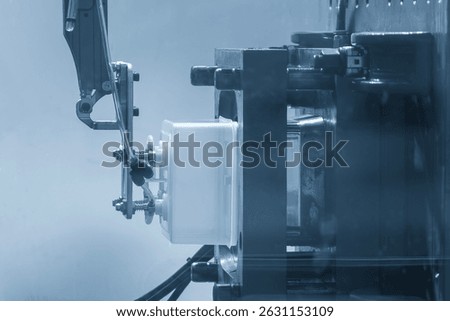 Close up scene material handling process the food container by robotic system from injection machine.  The food container production process by automatic system from plastic injection mold machine.