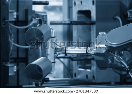 Close up scene material handling process the plastic drinking glass by robotic system .The food container box production process by automatic system from plastic injection mold machine.