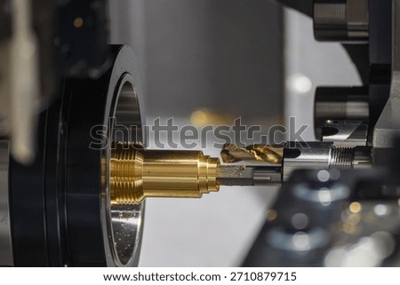 Close up scene multi-tasking CNC lathe machine swiss type hole drilling process the brass coupling parts. The hi-technology metal working processing by CNC turning machine.