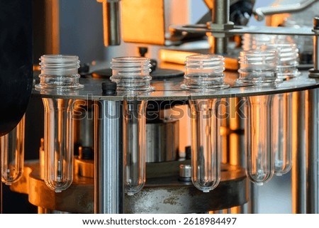 Close up scene the plastic bottle preform shape on the conveyor belt. The drinking water bottle manufacturing process by blow mold machine. 