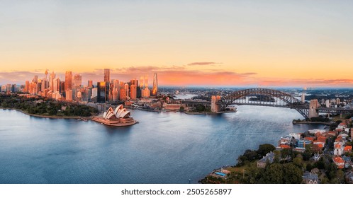 Close scenic aerial sunrise cityscape panorama of City of Sydney waterfront on shores of harbour by the Bridge. - Powered by Shutterstock