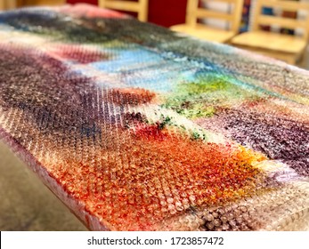 Up Close School Art Project Popping Bubble Wrap Covered In Paint On A Table.