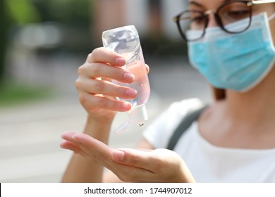 Close Up Of School Girl With Medical Mask Using Hand Sanitizer Gel In City Street. Antiseptic, Hygiene And Healthcare Concept. Focus On Hands.