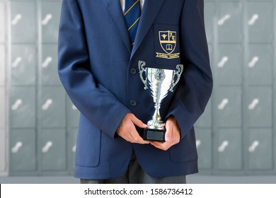 Close Up Of School Pupil In Uniform Holding Trophy