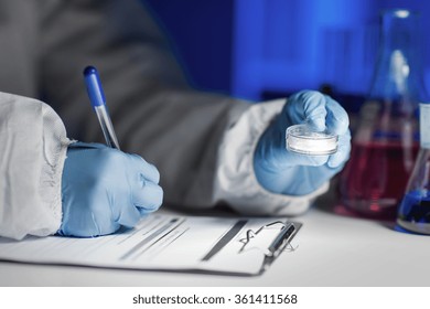 Close Up Of Scientist Writing Test Results In Lab