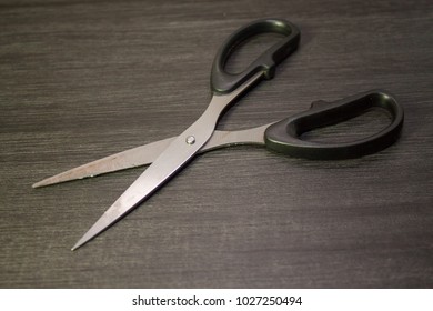 Close up of a scissors with black background.
