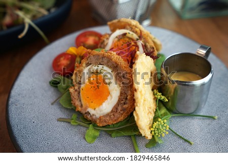 Close up Scotch egg consists of a whole soft or hard-boiled egg wrapped in sausage meat, coated in bread crumbs and baked or deep-fried