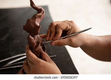 Close up of Sculptor artist creating The statue with clay.