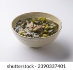 Close up of sea mustard soup with beef on ceramic bowl and white floor, South Korea
