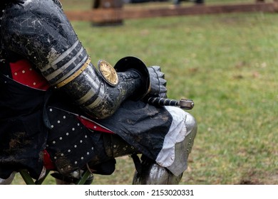 Close Up Of Seated Man's Arm In Black And Gold Medieval Knight's Armor For Armored Combat