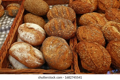 Close up selection of assorted fresh bread loaves on retail display of bakery store, high angle view