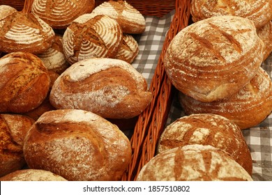 Close up selection of assorted fresh bread loaves on retail display of bakery store, high angle view
