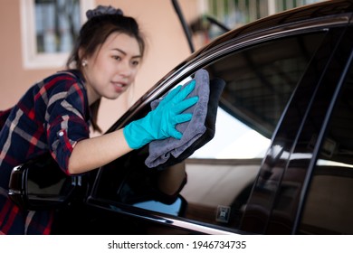 close up and selective focus on hand asian women wearing green gloves cleaning window car black with micro fiber stronger women car wash myself concept - Powered by Shutterstock