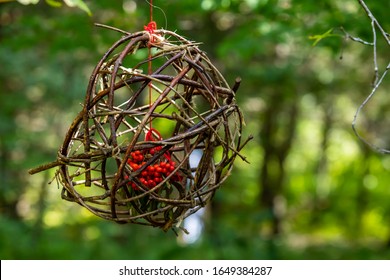 A Close Up Selective Focus View Of A Handmade Bird Feeder, Sticks And Twigs Foraged From Woodland To Create A Cage Housing Canadian Winterberries