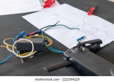 Close up selective focus view of remote controller and electricity cables around a black table with mechanism plan - Powered by Shutterstock - Get 15% off with code: PIKWIZARD15