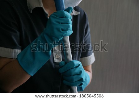 Close up and selective focused, rubber blue gloves, maid wearing it while working to protect infected bacteria, viruses, covid-19 for health care. Concept of cleanliness, covid-19, hygiene hands.