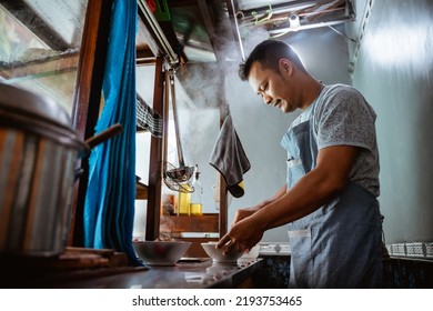 close up of seller prepares a serving of chicken noodles in a bowl on a cart - Powered by Shutterstock