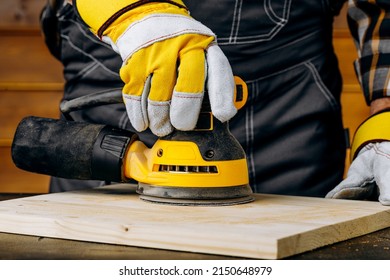 Close up of sending a wood with orbital sander at workshop. - Shutterstock ID 2150648979
