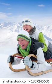 Close Up Of A Senior Couple Sledding Down The Snowy Slope At Full Speed With Motion Blur