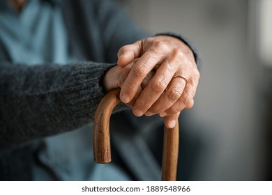 Close up of senior disabled woman hands holding walking stick. Detail of old woman hands holding handle of cane. Old lady holding walking stick.