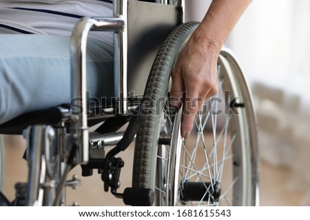 Close up of senior handicapped woman sit in wheelchair taken care of in hospital or home, mature disabled old lady grandmother in invalid carriage or wheel chair, elderly disability concept