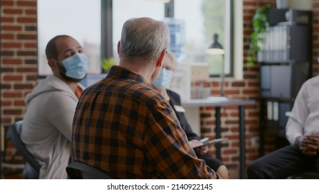 Close Up Of Senior Man Attending Aa Group Therapy Meeting With People. Person Wearing Face Mask And Having Conversation With Patients About Alcohol Addiction At Rehabilitation Program.