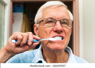 Close up of senior man brushing his teeth.