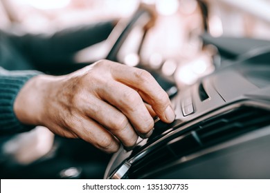 Close Up Of Senior Man Driving Car And Turning On Radio. Selective Focus On Hand.