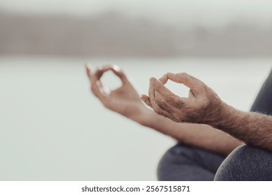 Close up of senior man hands holding yoga pose for meditation, outdoor, on beach. Healthy lifestyle, zen and body and mind balancing concept - Powered by Shutterstock