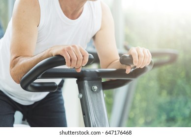 Close Up Senior Man Stretching On Exercise Machine Before Workout At The Gym. Copy Space.