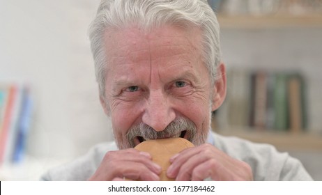 Close Up Of Senior Old Man Eating Burger