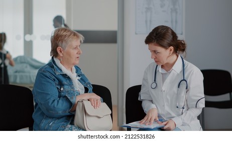 Close up of senior woman and doctor talking about diagnosis in waiting room, giving medical advice and support to sick patient. Pensioner discussing with medic about healthcare in lobby. - Powered by Shutterstock