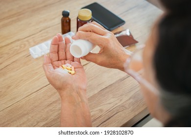 Close up of senior woman hands putting pills from a bottle in her hand. Old woman taking care herself for health. Health and Medical concept.