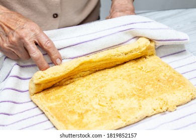 Close Up Of A Senior Woman Hands Rolling A Just Baked Sponge Cake