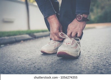 Close Up Of Senior Woman Hands Tying Sneakers. 